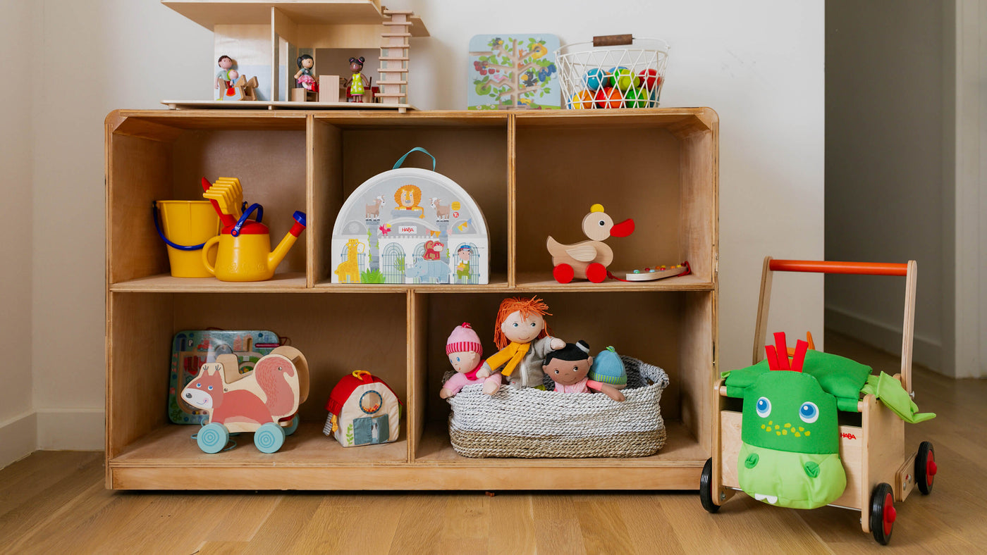 Wooden toy shelf filled with HABA toys