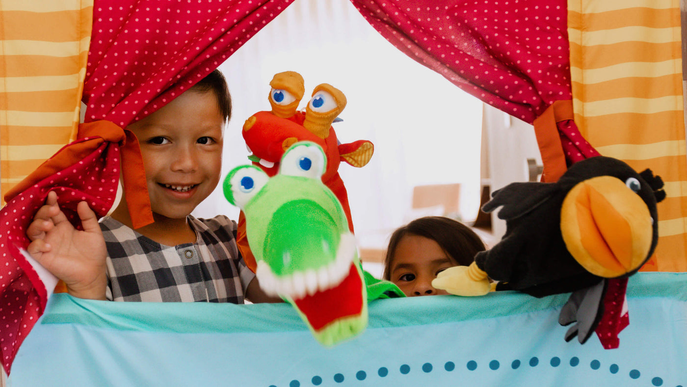 Boy and girl playing with puppets in the Hanging Doorway Puppet Theater