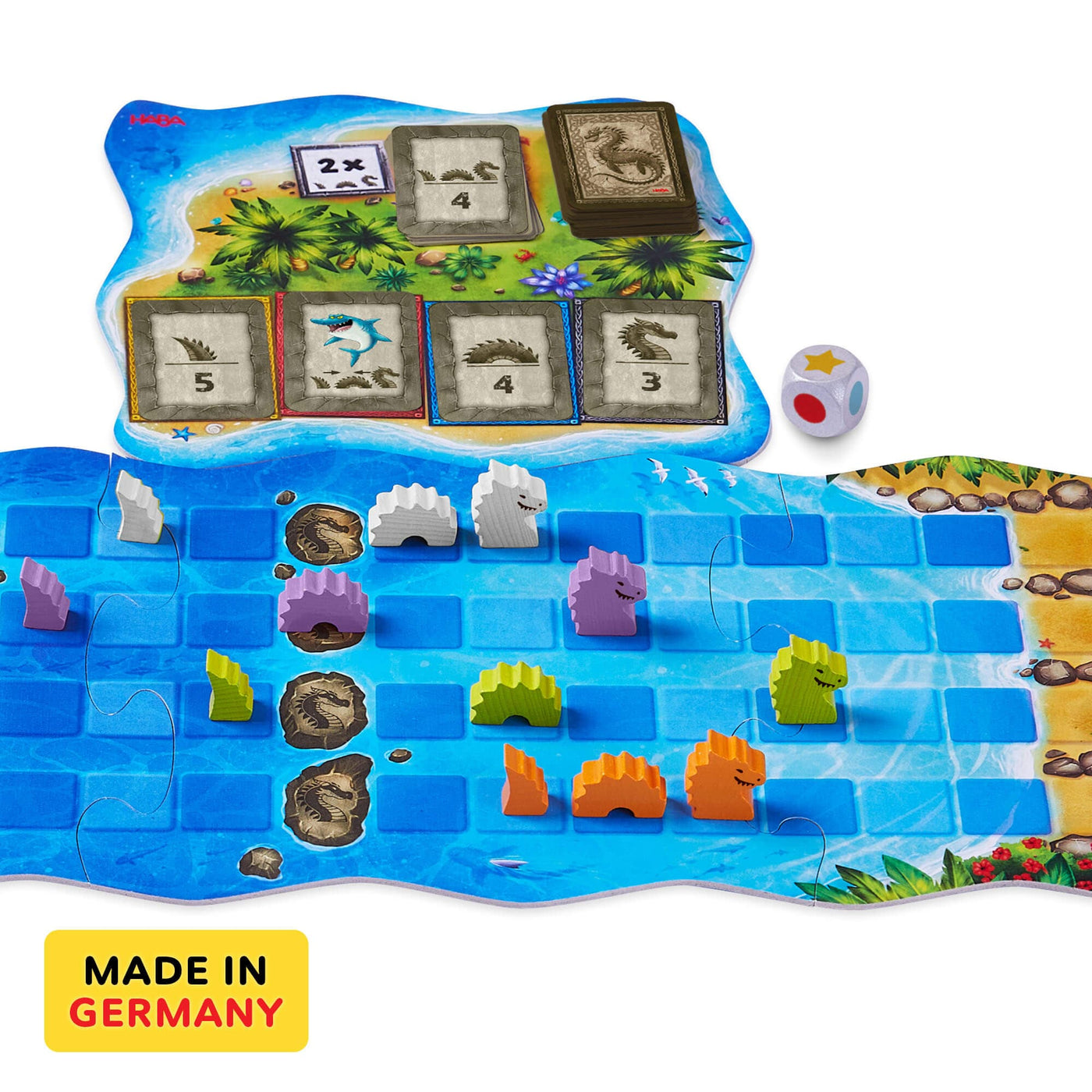 Water Dragons game board with gray, purple, green, and orange wooden pieces, cardboard game board, wooden die, and cards on a white backgrounc