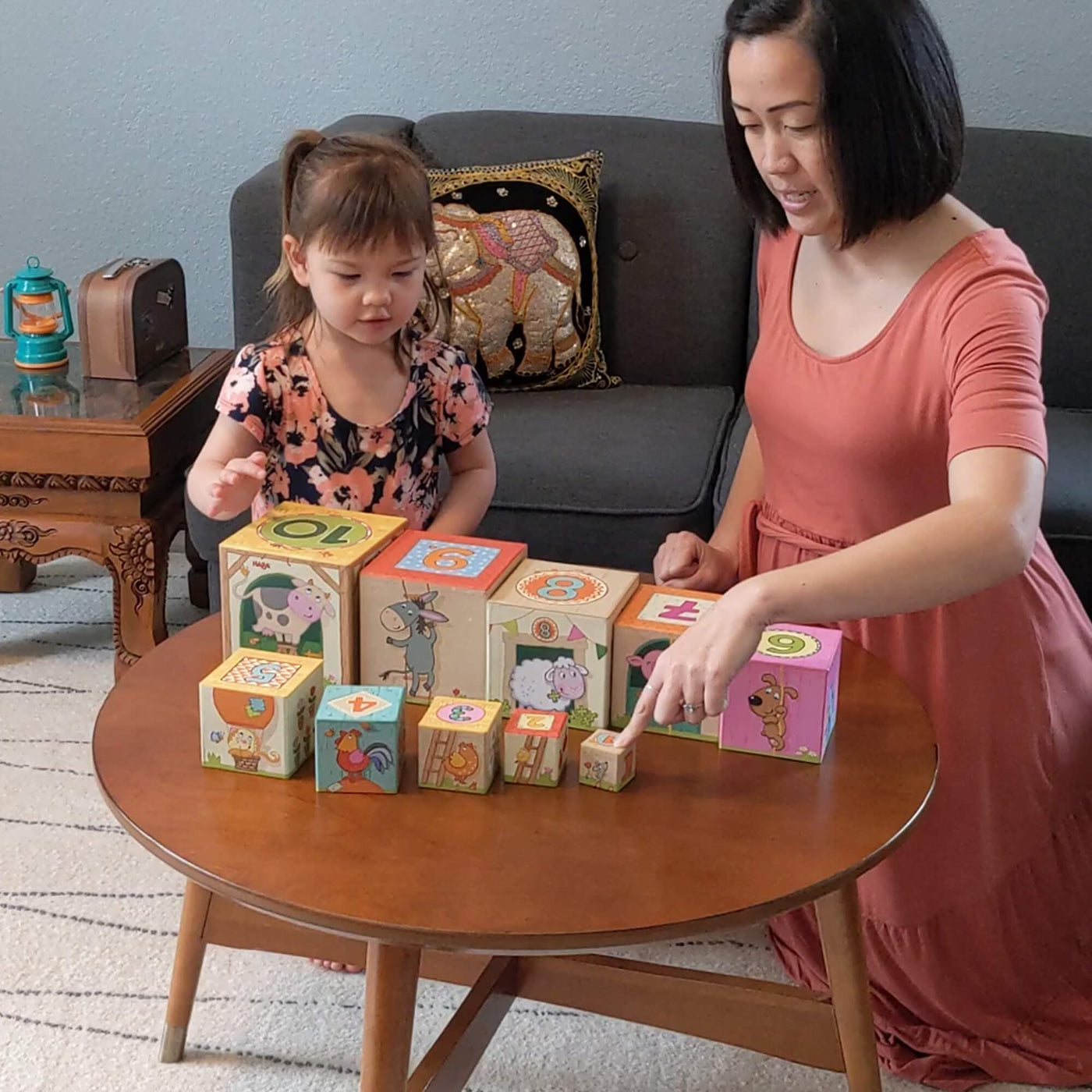 Mother and child playing with On the Farm Stacking and Nesting Cubes on wooden table