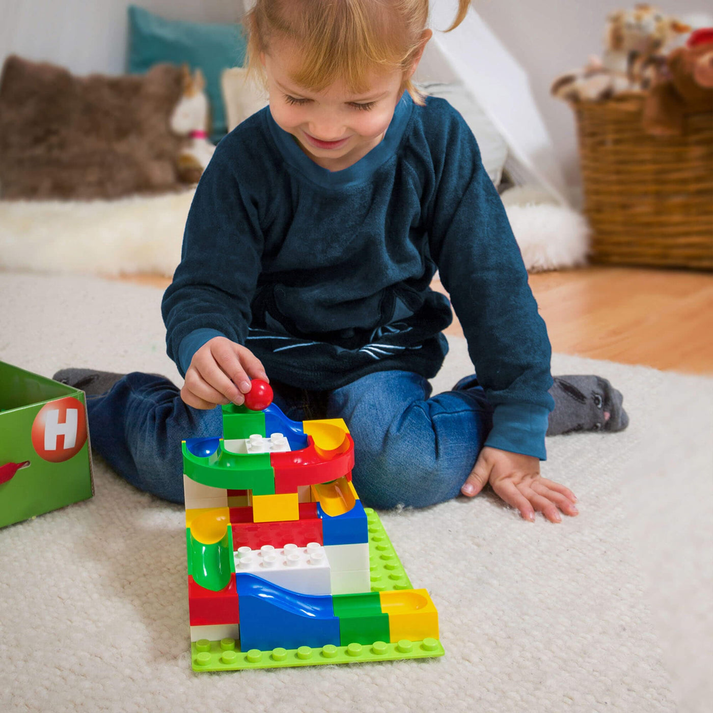 Girl playing with Hubelino Mini Building Box by HABA