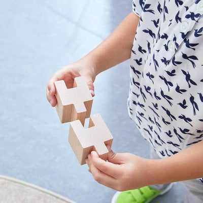 Child with 2 pieces of HABA Interlocking Wooden Blocks Construction Set