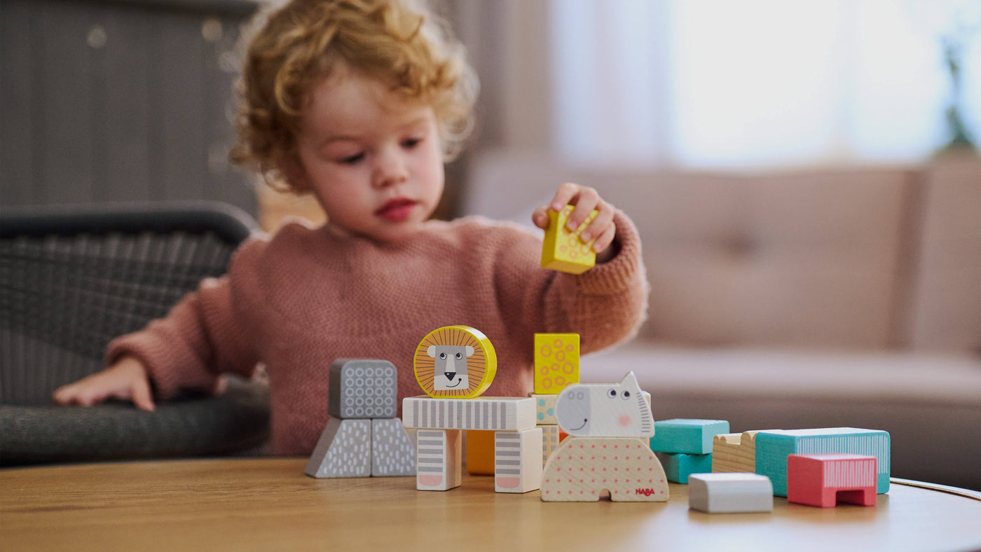 Child at table playing with HABA's Animal Parade Blocks
