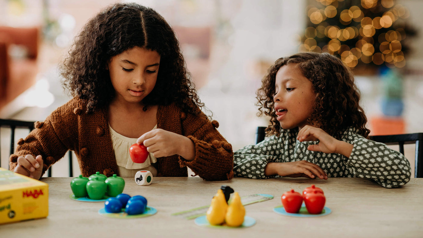 2 girls at table playing HABA's First Orchard