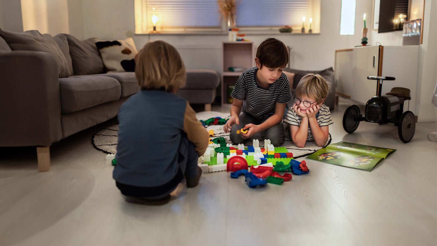 3 kids playing with Hubelino Marble Run on the living room floor