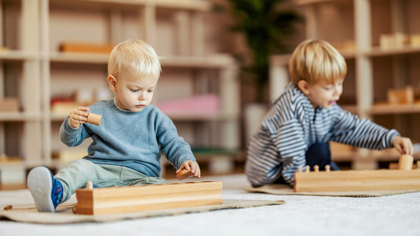 Two children playing with wooden blocks on the floor in a cozy room setting.