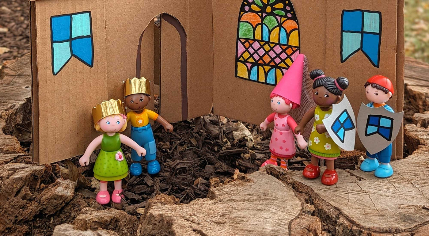 A cardboard castle craft sits with HABA Little Friends Dolls.