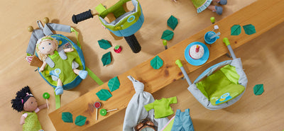 HABA dolls with backpack, table seat, and bike seat accessories