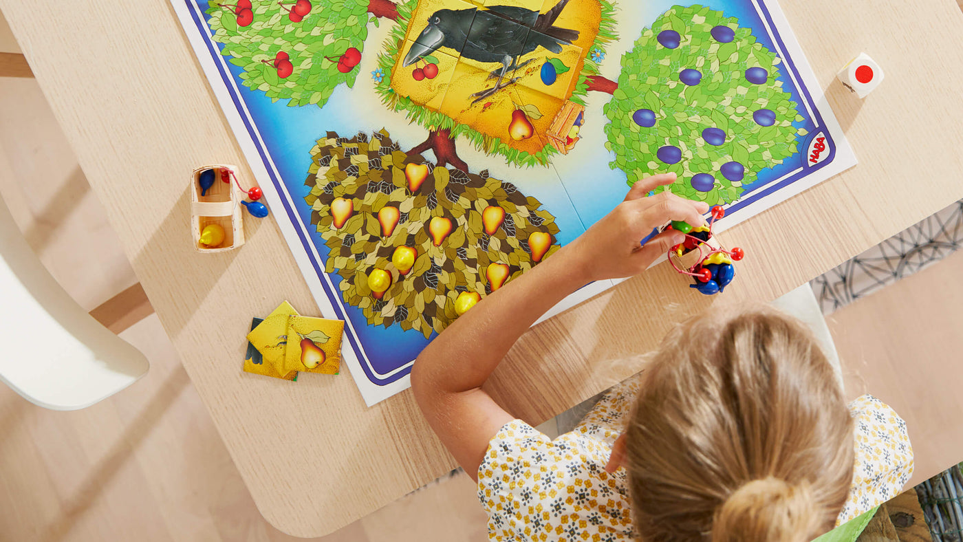 Overhead photo of girl playing Orchard Cooperative Board Game