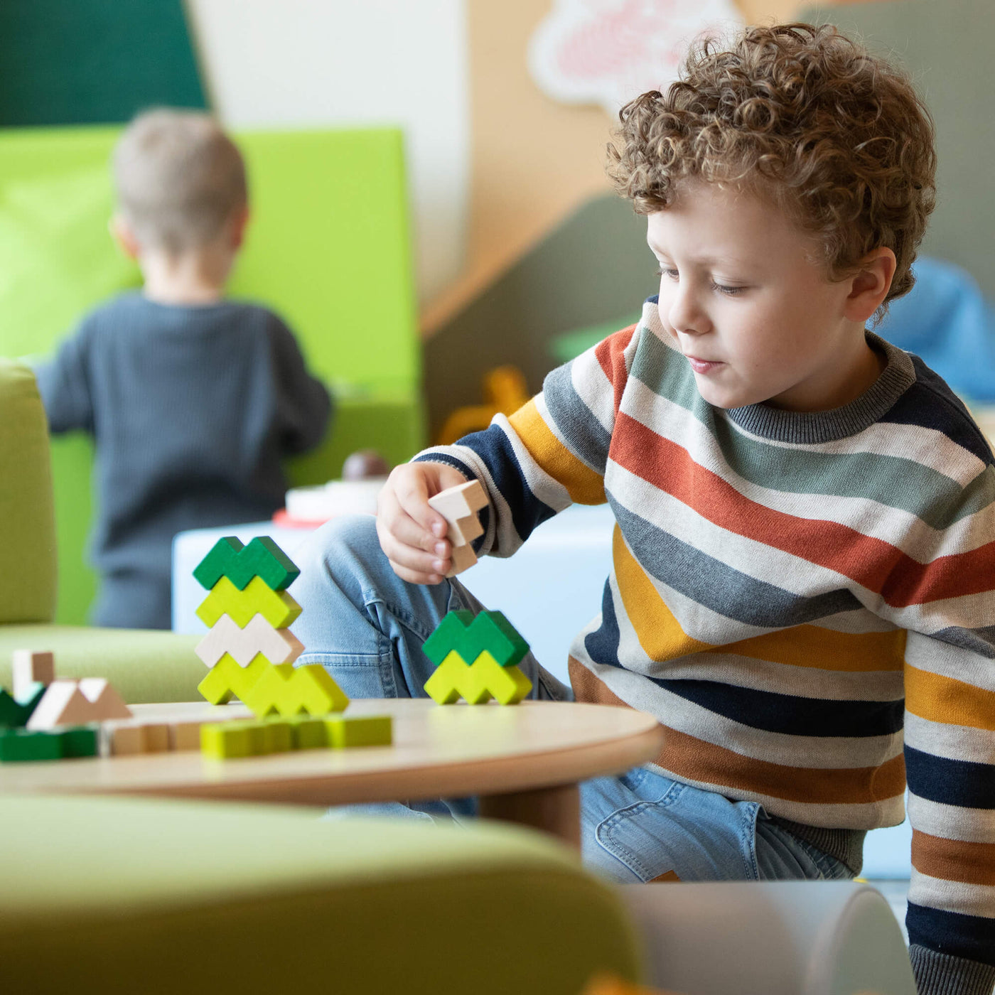 Child playing with 3D Viridis Wooden Stacking Game building blocks in a colorful room