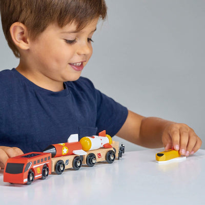 Child playing with a toy train set on a gray background