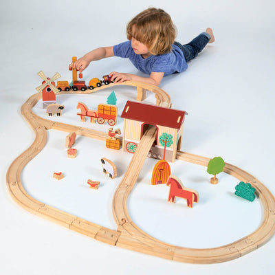 Child playing with a wooden train set on a white background