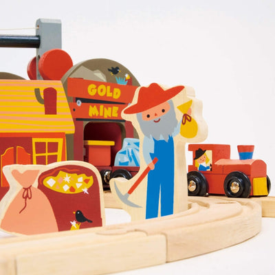 Wooden toy set with a gold mine scene, including a character with a pickaxe and a train.