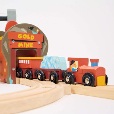 Wooden toy train set with a gold mine station on a white background