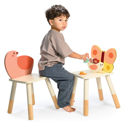 Child playing on butterfly and bird shaped chairs on a white background