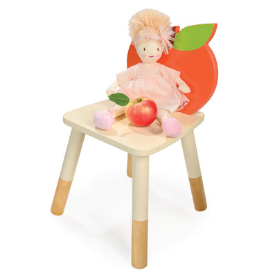 Wooden chair with a doll and apples on a white background