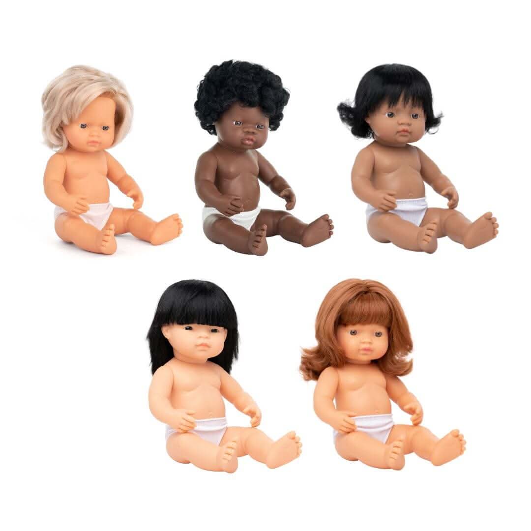 A set of five Miniland Realistic Montessori Dolls, representing Blonde, Red-Haired, Black, Hispanic, and Asian ethnicities. Each 12-inch anatomically correct girl doll is crafted from soft vinyl, designed for educational and inclusive play.