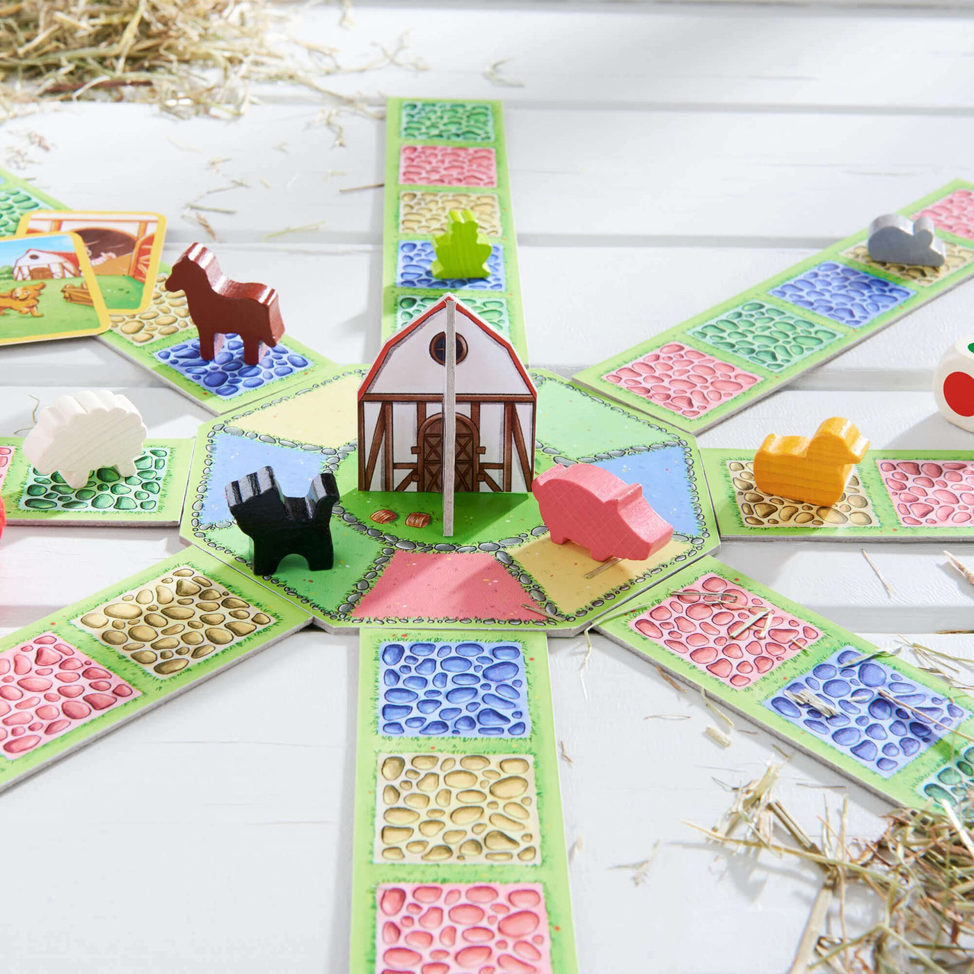 Barnyard Bunch game by HABA with barn and wooden pieces on wood floor