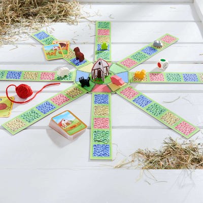 Barnyard Bunch Game by HABA on wood floor with wooden pieces