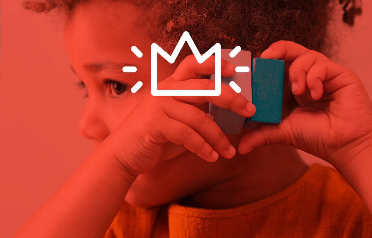 Girl holding a block up to her ear in a red tint with a white crown icon