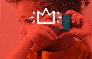 Girl holding a block up to her ear in a red tint with a white crown icon