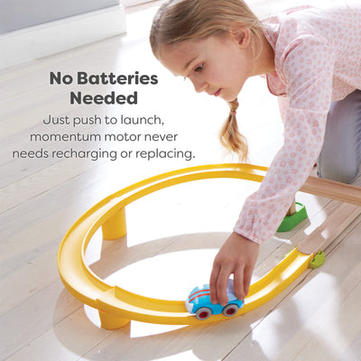 Child playing with a toy track set on a wooden floor, with text indicating no batteries are needed.
