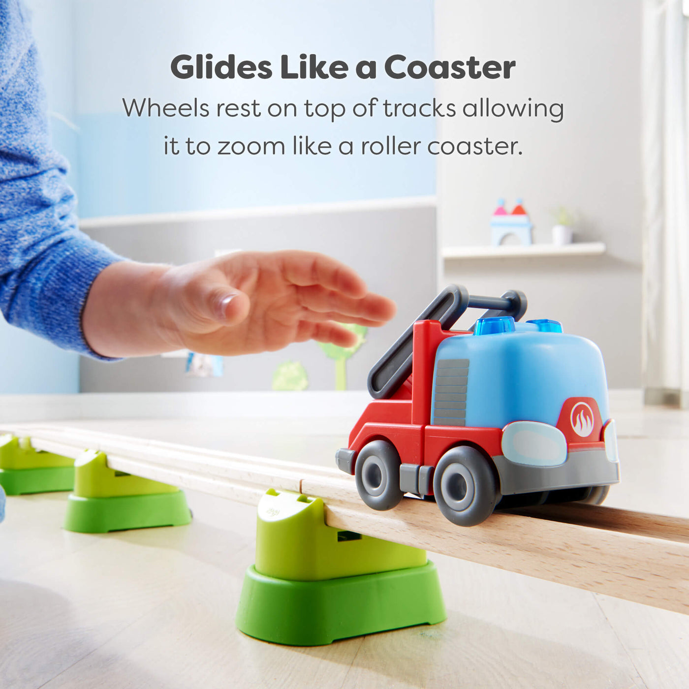 Toy fire truck on a track with text describing that is sit on top of the track so it glides like a roller coaster
