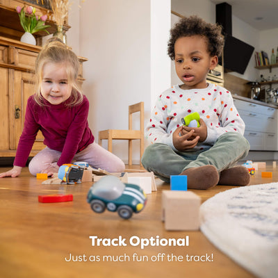 Two children playing with toys on a wooden floor in a home setting with text reading "Track optional, Just as much fun off the track!"