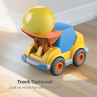 Toy wheel loader with a yellow ball on top, placed on a wooden floor.