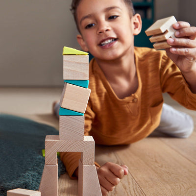 Child playing with Crooked Tower Wooden Blocks - HABA USA