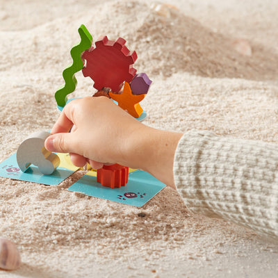 Child playing with wooden game piece and HABA's Flotsam Float Game