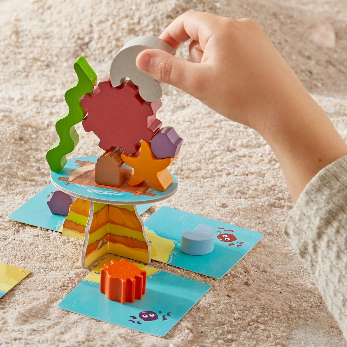Child stacking wooden game pieces for HABA's Flotsam Float game