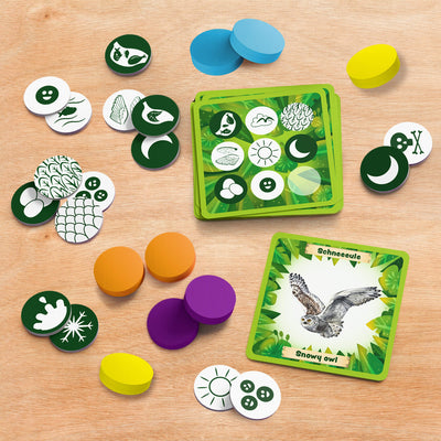 Animals Around the World Bingo game components including cards and tokens on a wooden surface