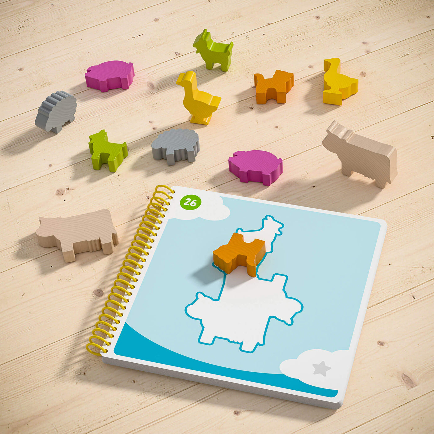 HABA Logic! Games Bao's Cloudland pieces of colorful wooden animal shapes scattered around a children's activity book on a wooden surface