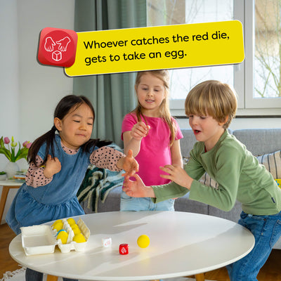 Children playing a game with Dancing Eggs in a living room. Text overlay says "Whoever catches the red die, gets to take an egg."