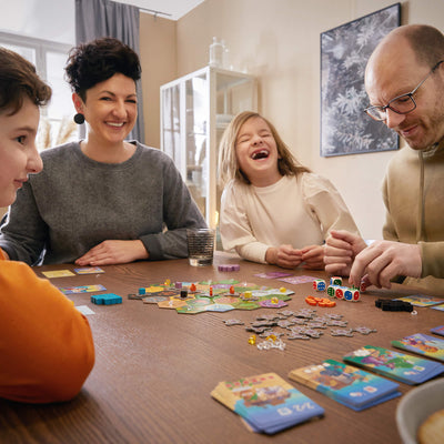 Family sitting around a table playing King of the Dice Board Game