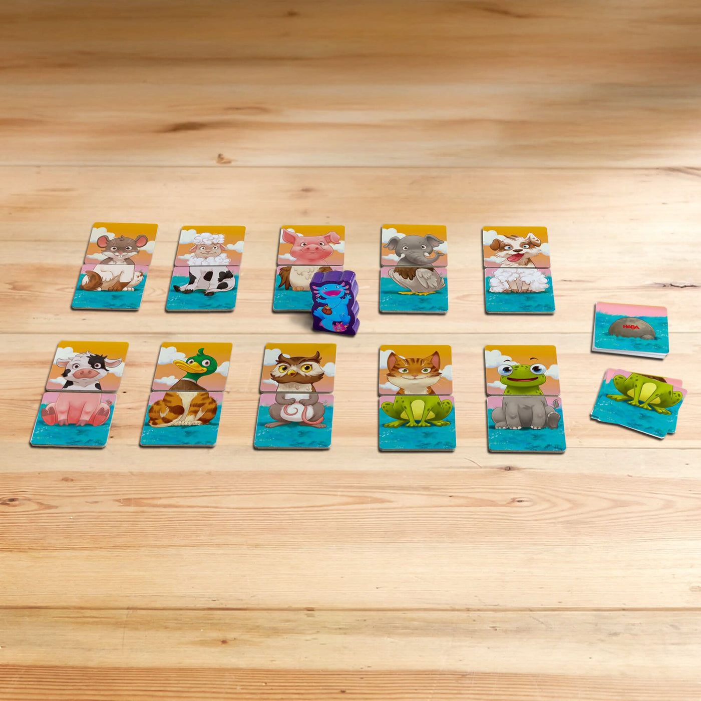 Animal-themed playing cards on a wooden surface with various cartoon animals like pigs, elephants, and frogs.