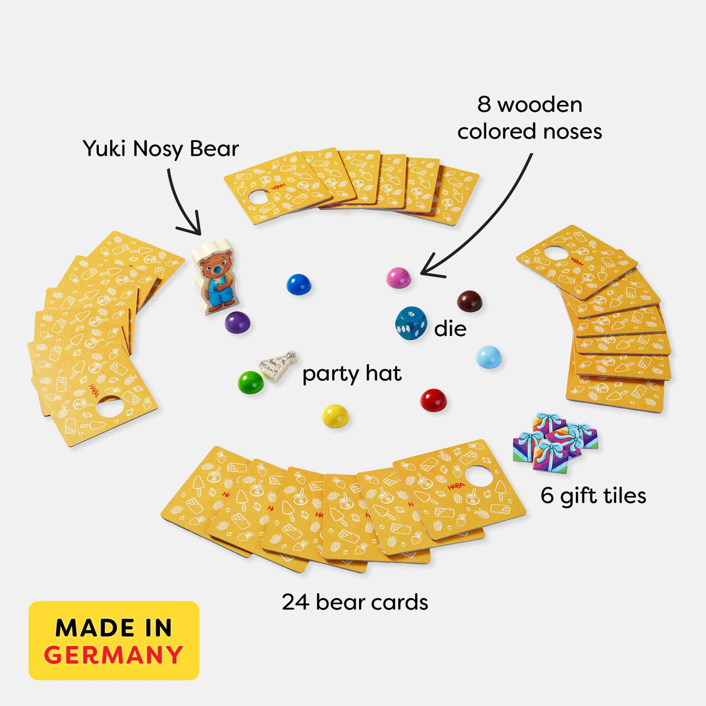 HABA Nosy Bear Game includes Yuki Nosy Bear wooden game piece, 8 wooden colored noses, wooden party hat, wooden die, 6 gift tiles, and 24 bear cards. Made in Germany.