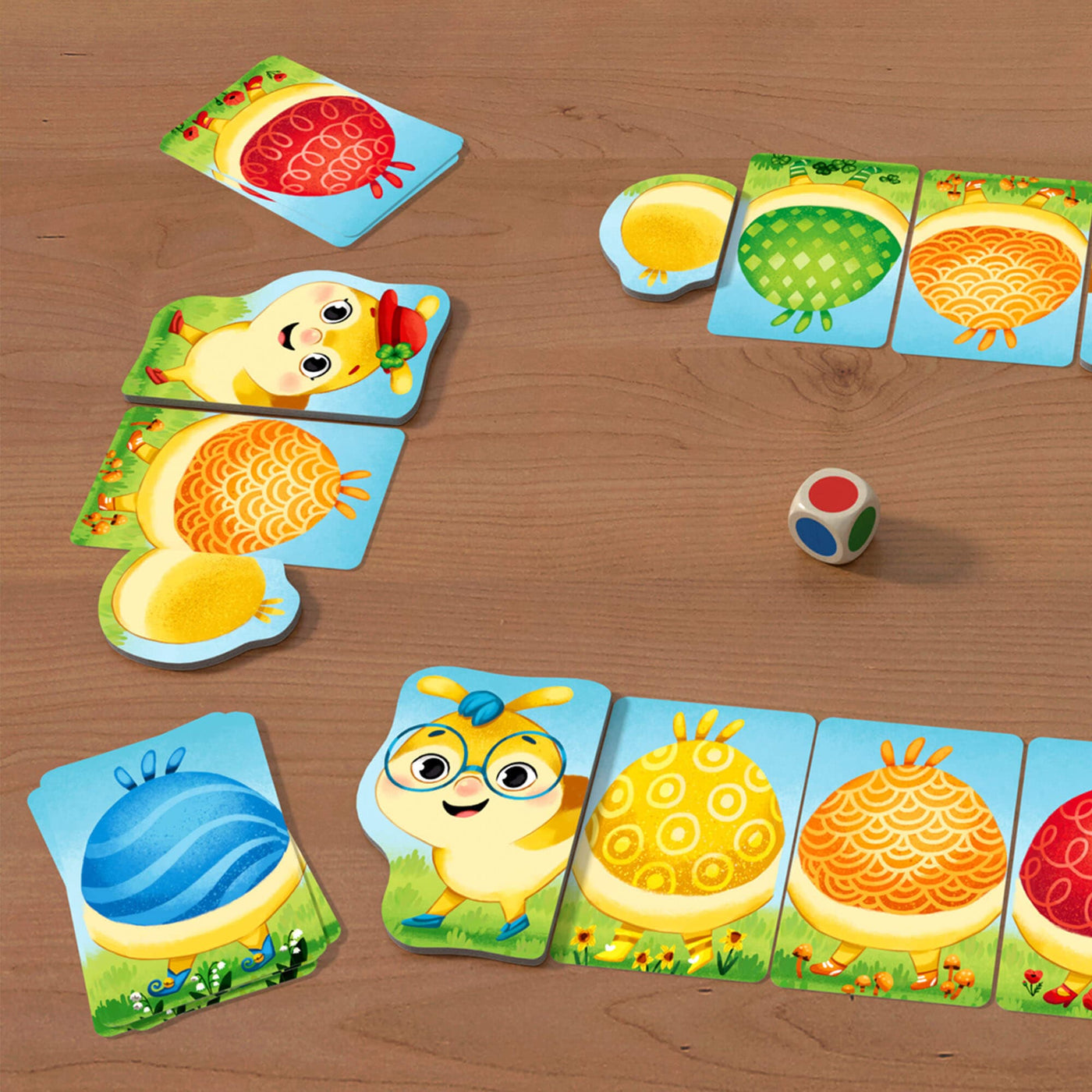 Rainbow Caterpillar game with wooden die on table