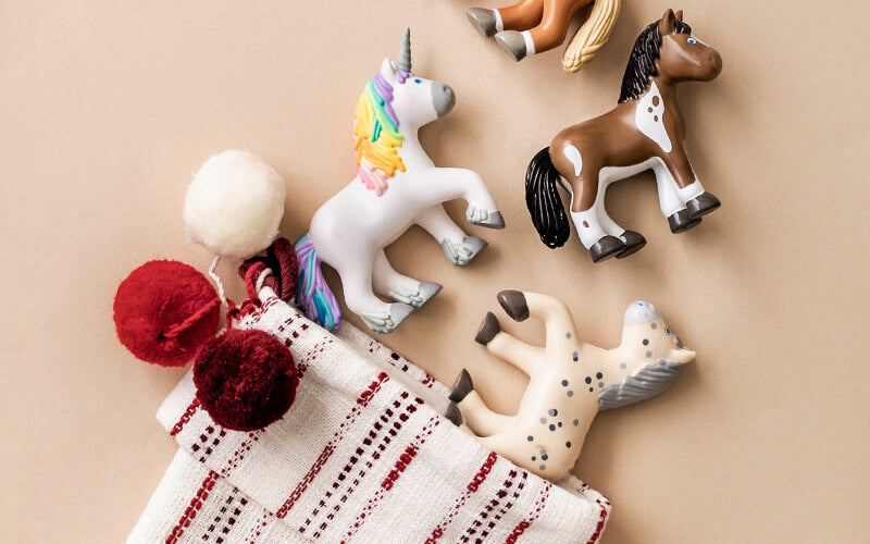 Flat lay of a Christmas stocking with 4 Little Friends horses coming out of it