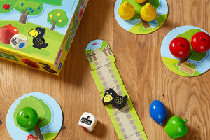 HABA First Orchard board game setup with fruit pieces, a raven game piece, and illustrated box.