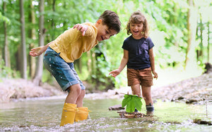 Boy and girl standing in a creek launching Terra Kids Cork Boat