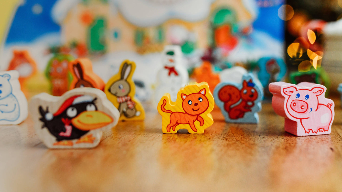 Colorful wooden animal toys from the HABA My First Advent Calendar - Farmyard Animals, including an orange cat, a black bird, and a pink pig.