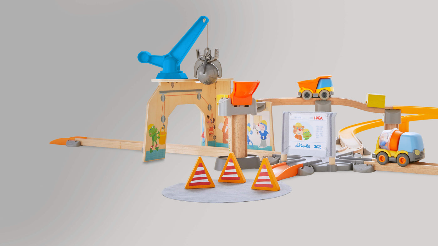 Toy construction playset with crane, trucks, tracks, and traffic cones.