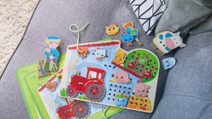Overhead view of HABA's Farm Threading & Lacing Game on a couch