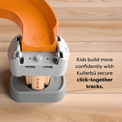 Close up Kullerbu Colorful Curves - Build & Grow Ball Track Set with orange and gray components on a wooden surface. Text reads 'Kids build more confidently with Kullerbü secure click-together tracks.'
