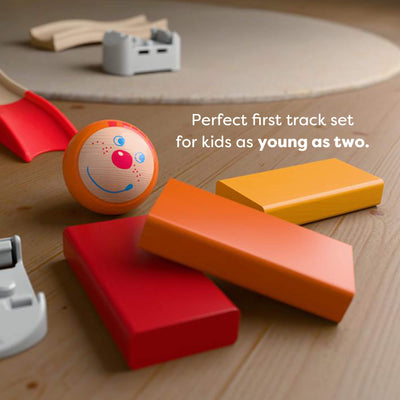 Colorful toy track set on a wooden surface with text reading 'Perfect first track set
for kids as young as two.'