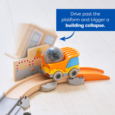 Toy construction set with moving parts and text indicating that if you drive past the platform it triggers a building collapse