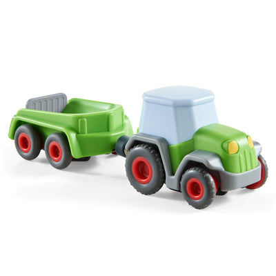 Toy tractor with a green trailer on a white background