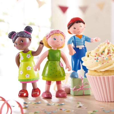 Three Little Friends figures with a cupcake and presents on a festive background